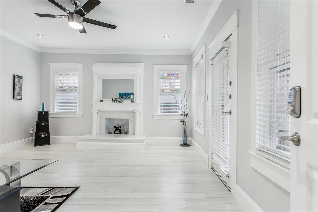 4719 Junius Street, Unit 3 Dallas, TX 75246 - Photo 3 of 36 a view of a livingroom with a fireplace a ceiling fan and windows
