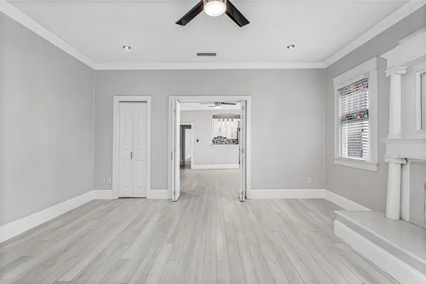 an empty room with fan and windows