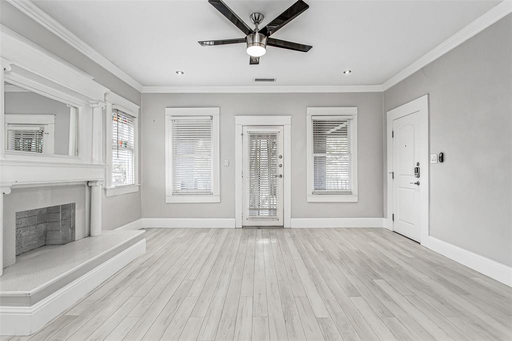4719 Junius Street, Unit 3 Dallas, TX 75246 - Photo 9 of 38 a view of an empty room with a fireplace and a window