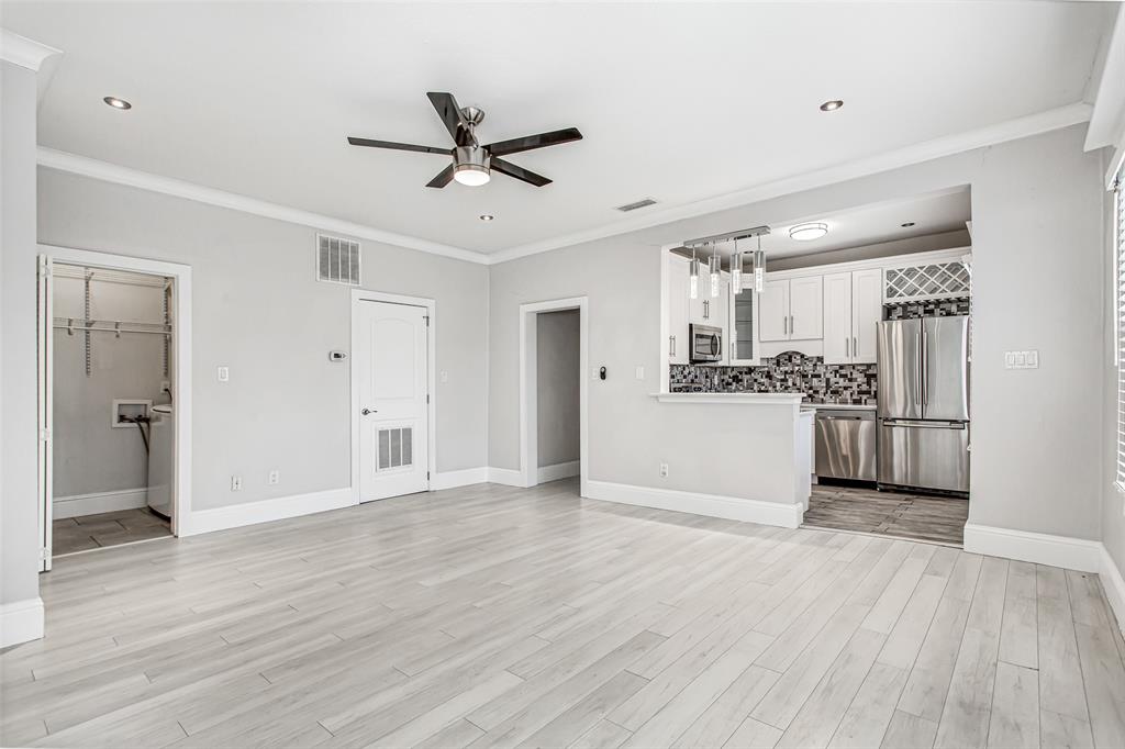 4719 Junius Street, Unit 3 Dallas, TX 75246 - Photo 10 of 38 a view of a kitchen with a refrigerator and a wooden floor