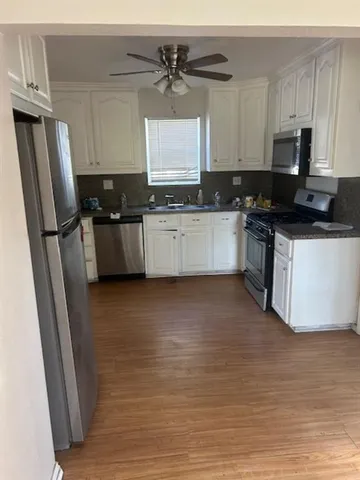a kitchen with stainless steel appliances a refrigerator sink and microwave