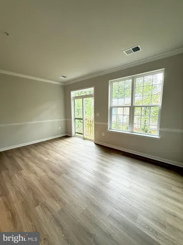 a living room with a bed furniture and a wooden floor