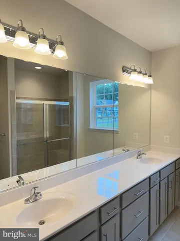 a bathroom with a sink toilet a mirror and shower
