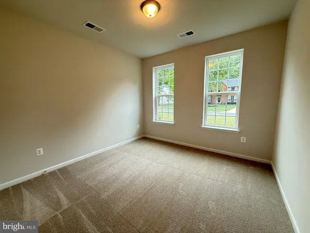 an aerial view of a residential houses with outdoor space and trees all around