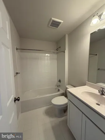 a view of a park with large trees and wooden fence