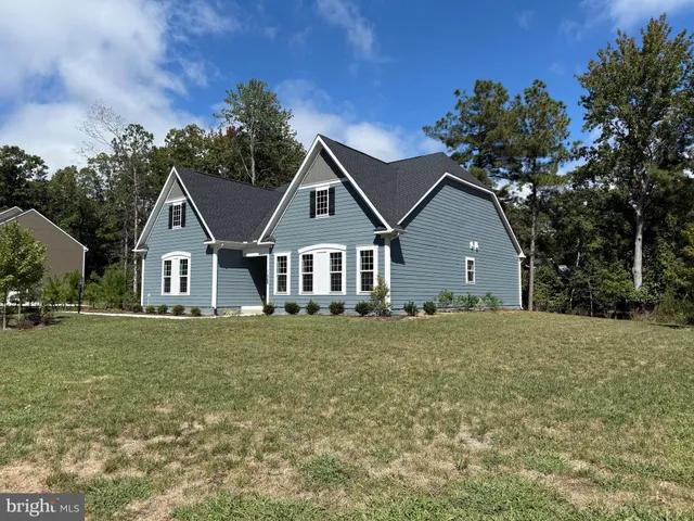 a front view of a house with a garden and trees