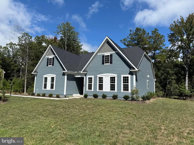 a front view of a house with a yard and trees