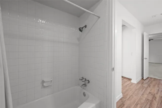 a view of empty room with wooden floor and fireplace