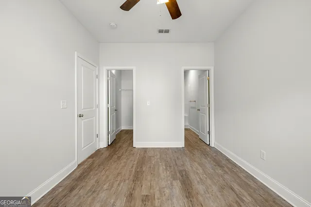 an empty room with closet and windows