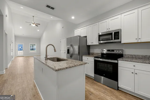 a kitchen with stainless steel appliances granite countertop a sink stove and refrigerator