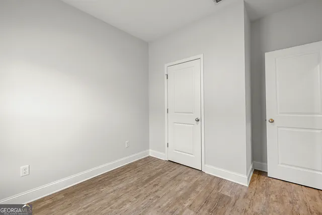 a view of an empty room with wooden floor