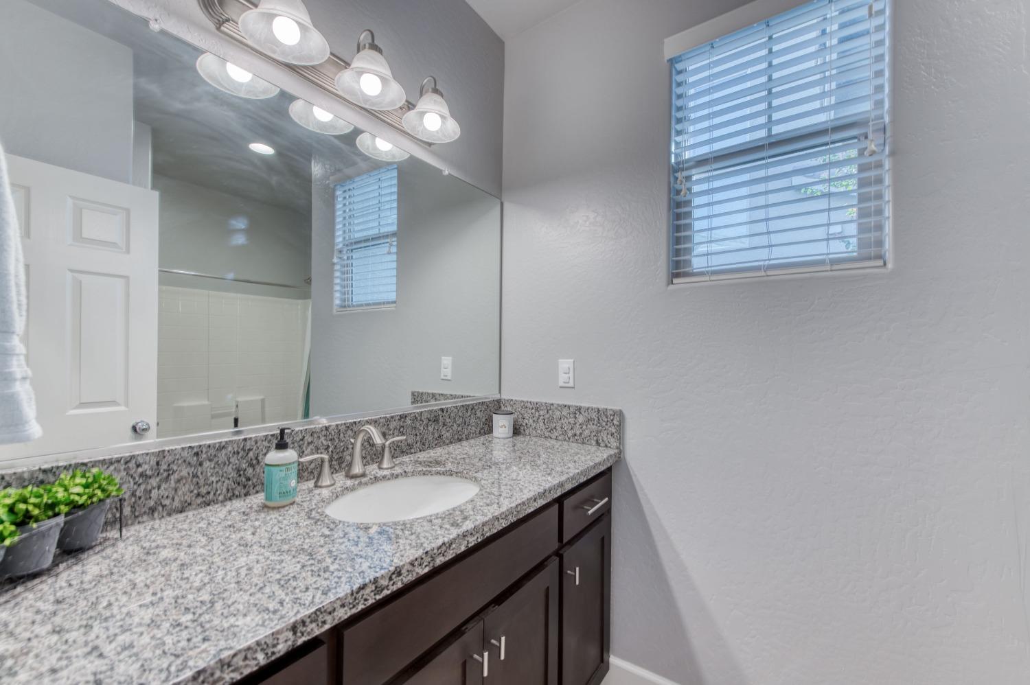 3539 Taylor Lane Clovis, CA 93619 - Photo 21 of 33 a bathroom with a granite countertop sink and a mirror
