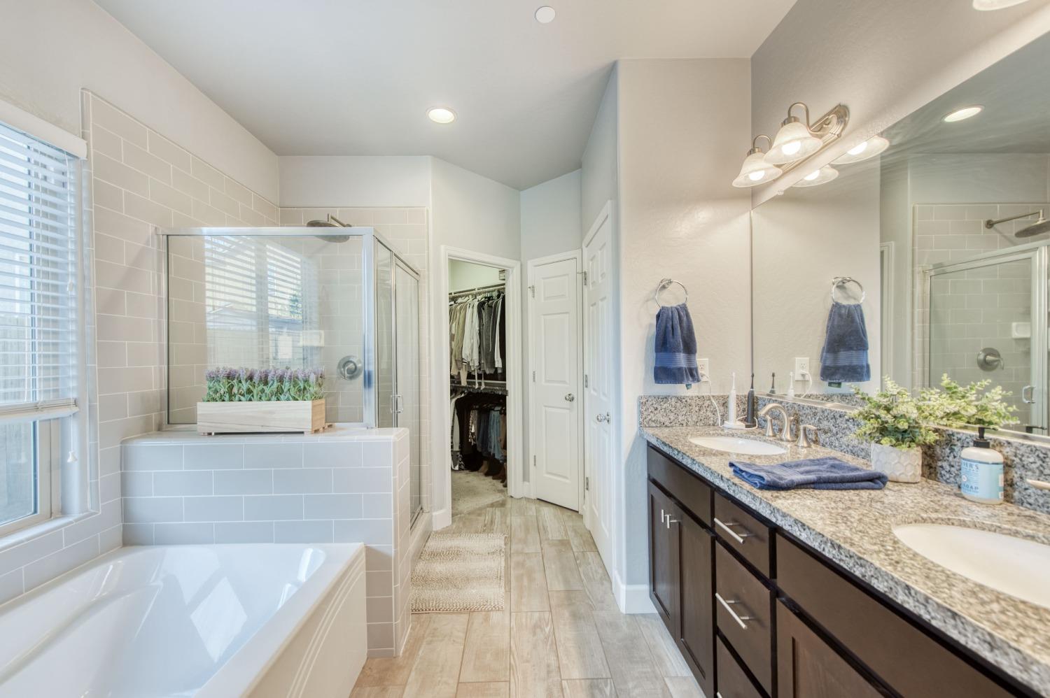 3539 Taylor Lane Clovis, CA 93619 - Photo 25 of 33 a spacious bathroom with a granite countertop sink mirror and a bath tub