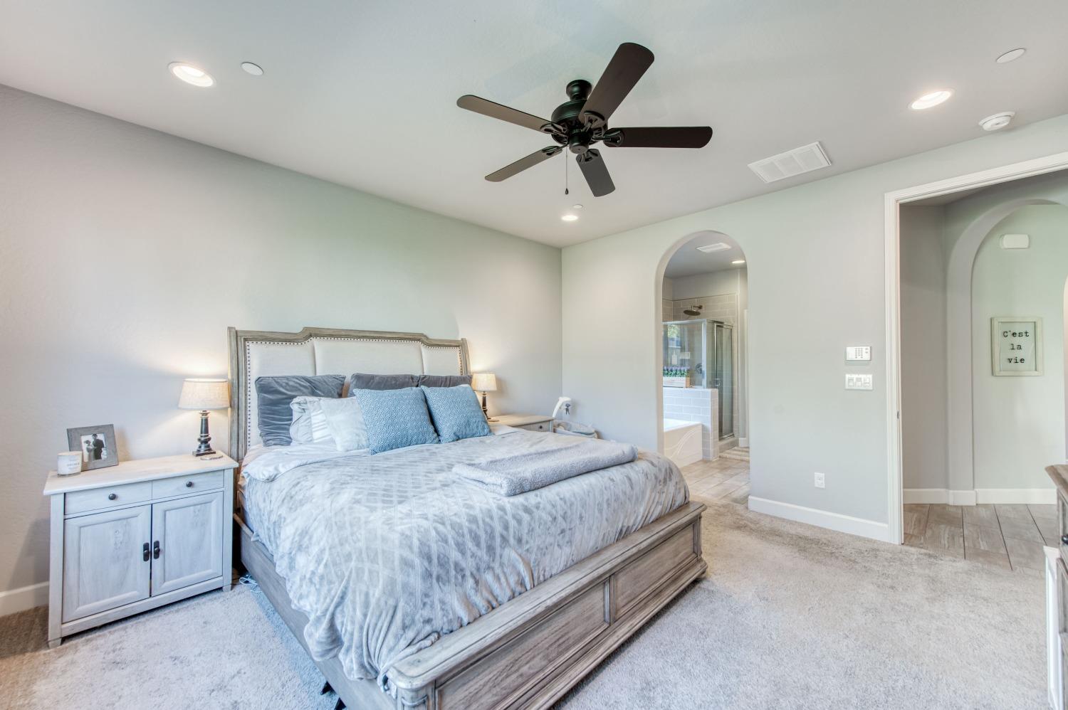 3539 Taylor Lane Clovis, CA 93619 - Photo 29 of 33 a bedroom with a large bed and a chandelier