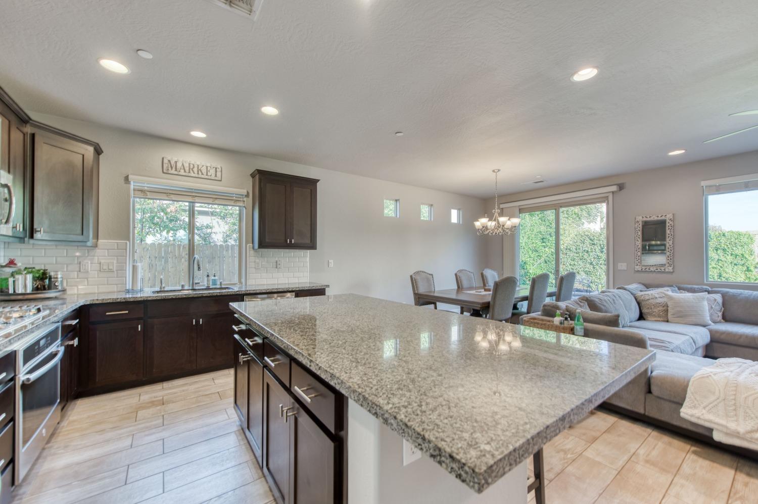 3539 Taylor Lane Clovis, CA 93619 - Photo 7 of 33 a kitchen with center island a sink dishwasher a stove and a refrigerator with wooden floor