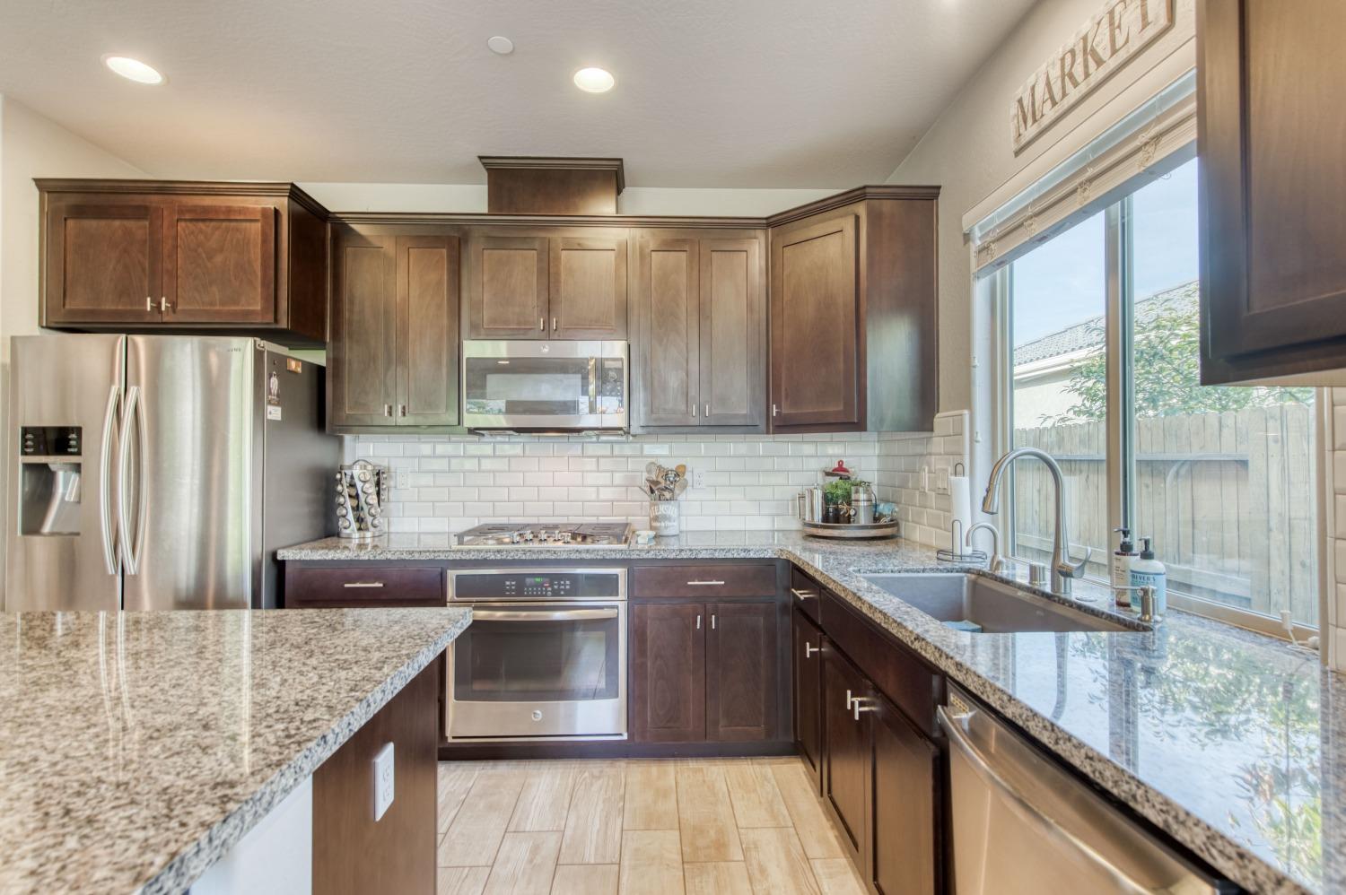 3539 Taylor Lane Clovis, CA 93619 - Photo 10 of 33 a kitchen with stainless steel appliances granite countertop a sink stove and refrigerator