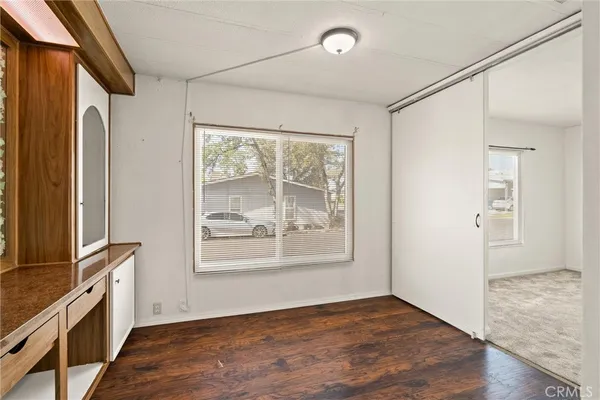 a room with a balcony a sink and a large mirror with wooden floor
