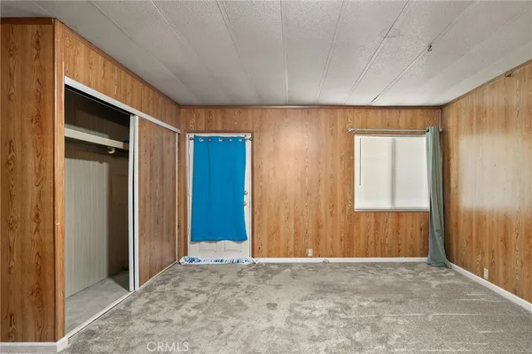 a view of an empty room with window and bathroom
