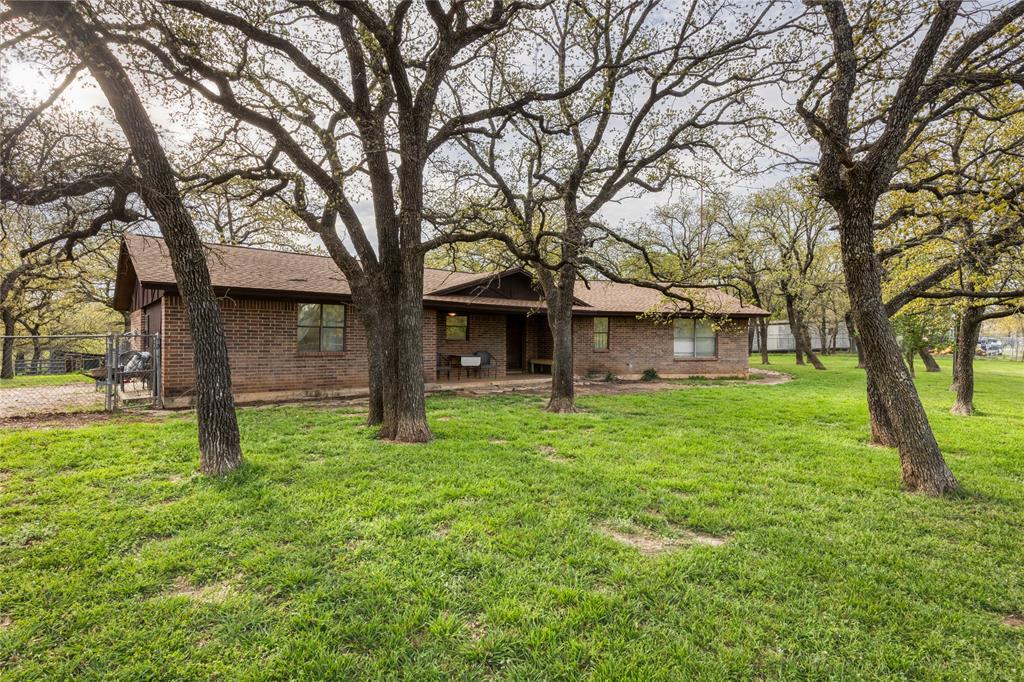 243 County Road 3851 Poolville, TX 76487 - Photo 3 of 34 a view of a house with yard and a tree