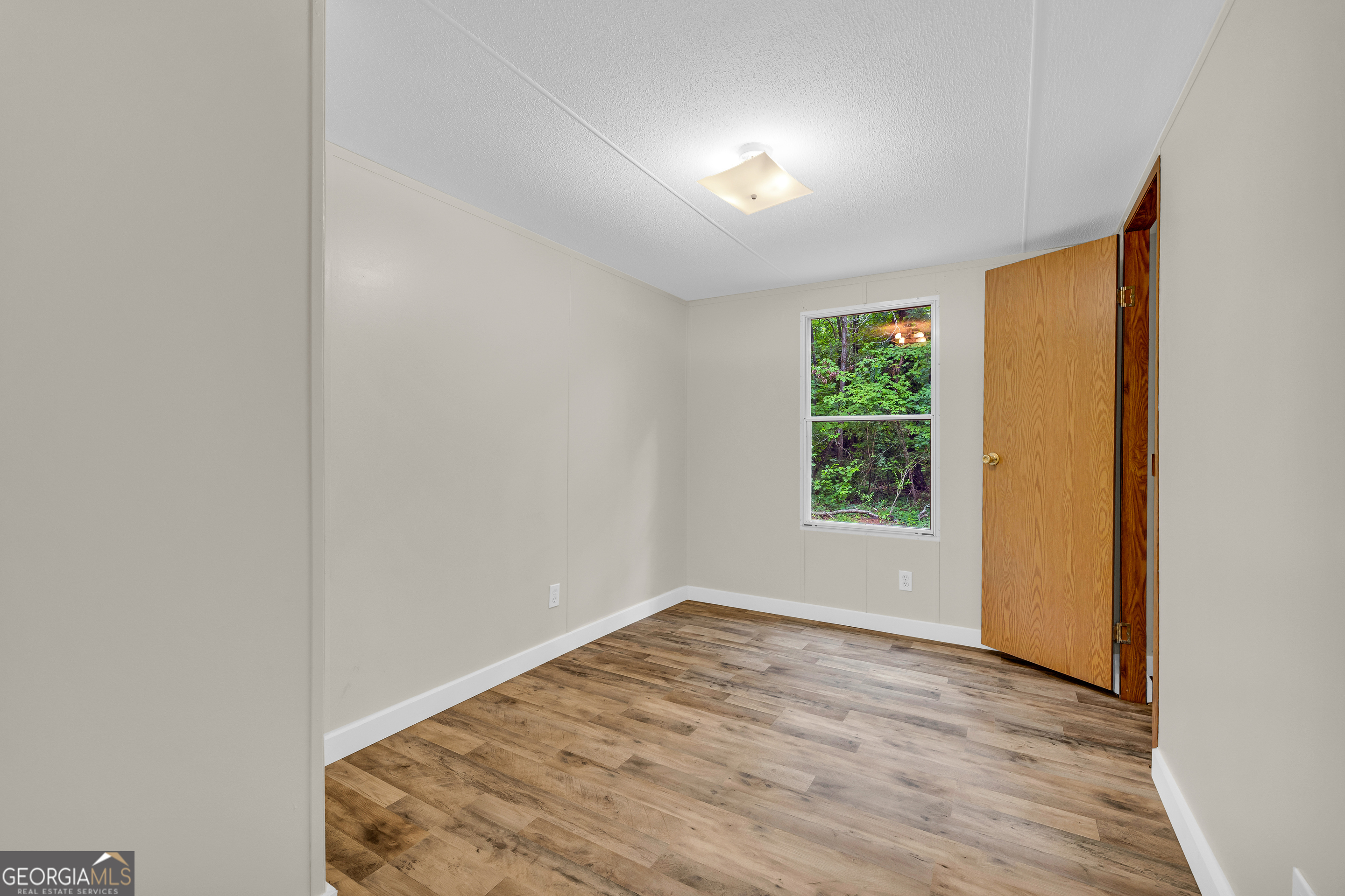 162 Stillwater Road Lavonia, GA 30553 - Photo 13 of 45 an empty room with wooden floor and windows