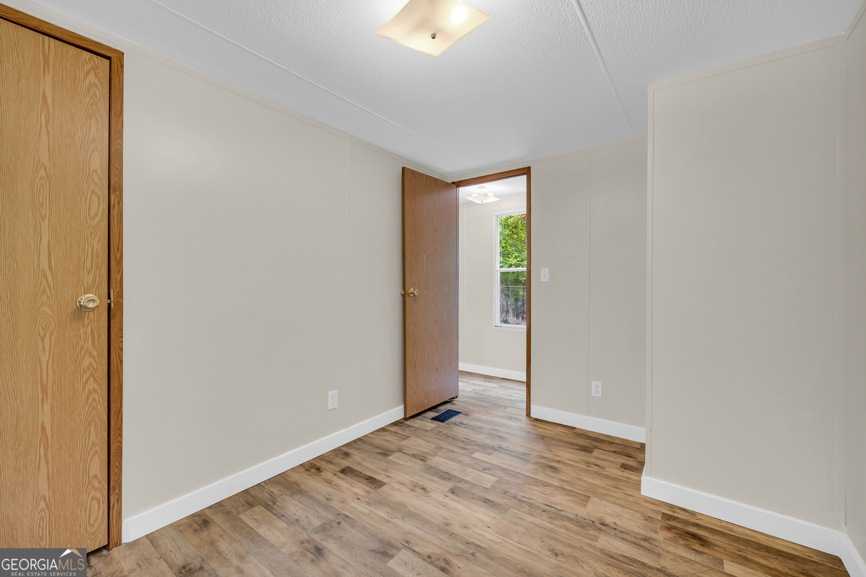 162 Stillwater Road Lavonia, GA 30553 - Photo 14 of 45 a view of an empty room and window with wooden floor