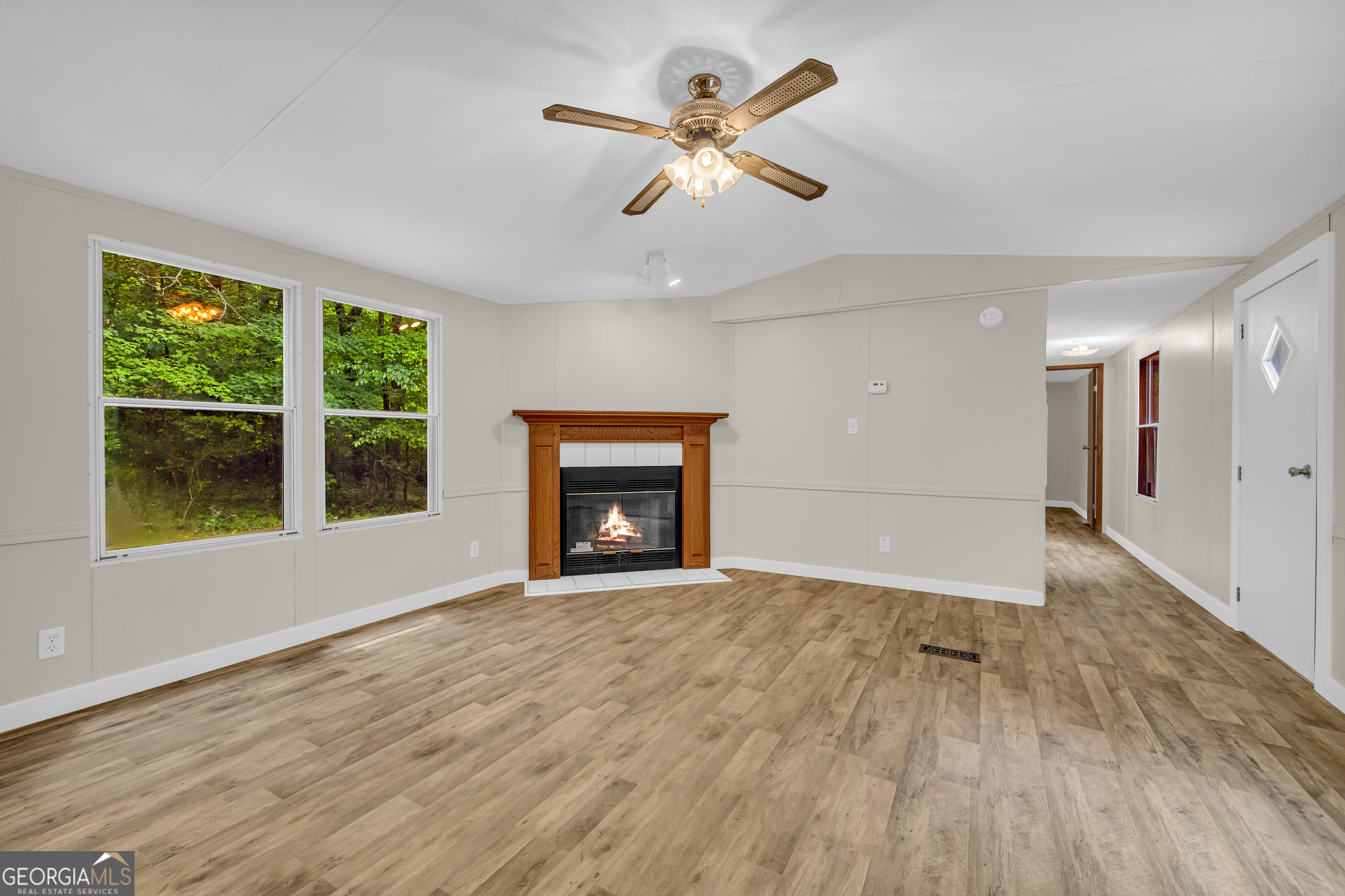162 Stillwater Road Lavonia, GA 30553 - Photo 10 of 45 a view of an empty room with a window and wooden floor