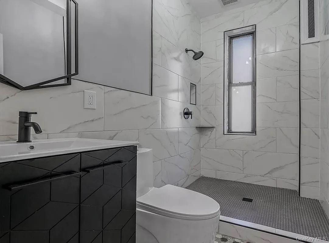 643 Decatur Street, Unit 1 Brooklyn, NY 11233 - Photo 14 of 27 a bathroom with a sink a toilet and shower