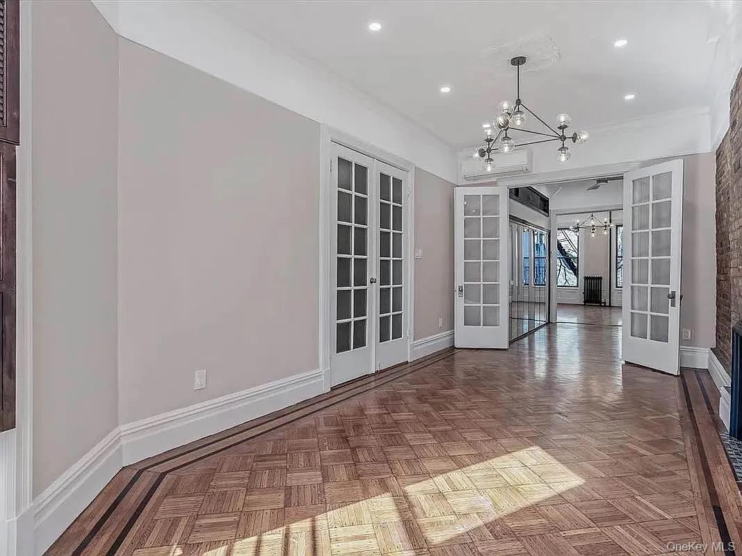 643 Decatur Street, Unit 1 Brooklyn, NY 11233 - Photo 19 of 27 a view of empty room with wooden floor and windows