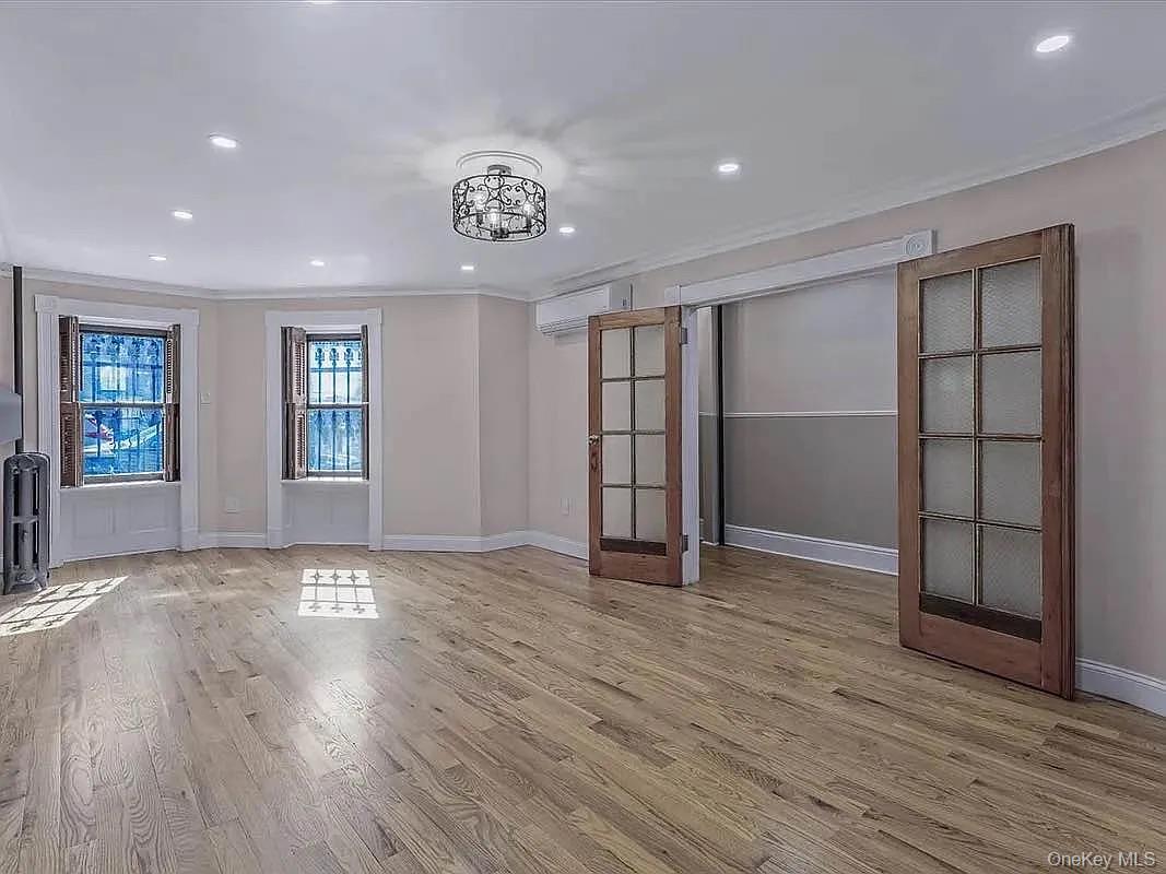 643 Decatur Street, Unit 1 Brooklyn, NY 11233 - Photo 3 of 27 an empty room with wooden floor closet and windows