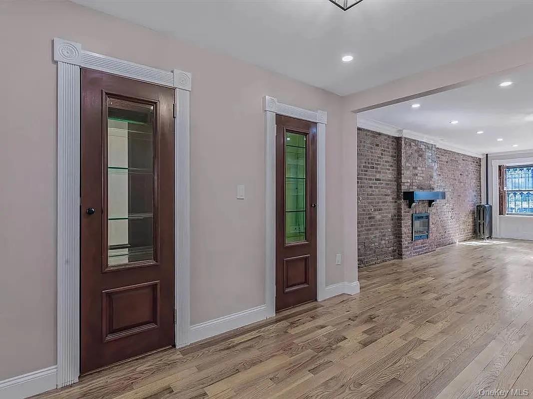 643 Decatur Street, Unit 1 Brooklyn, NY 11233 - Photo 5 of 27 an empty room with wooden floor and way to kitchen