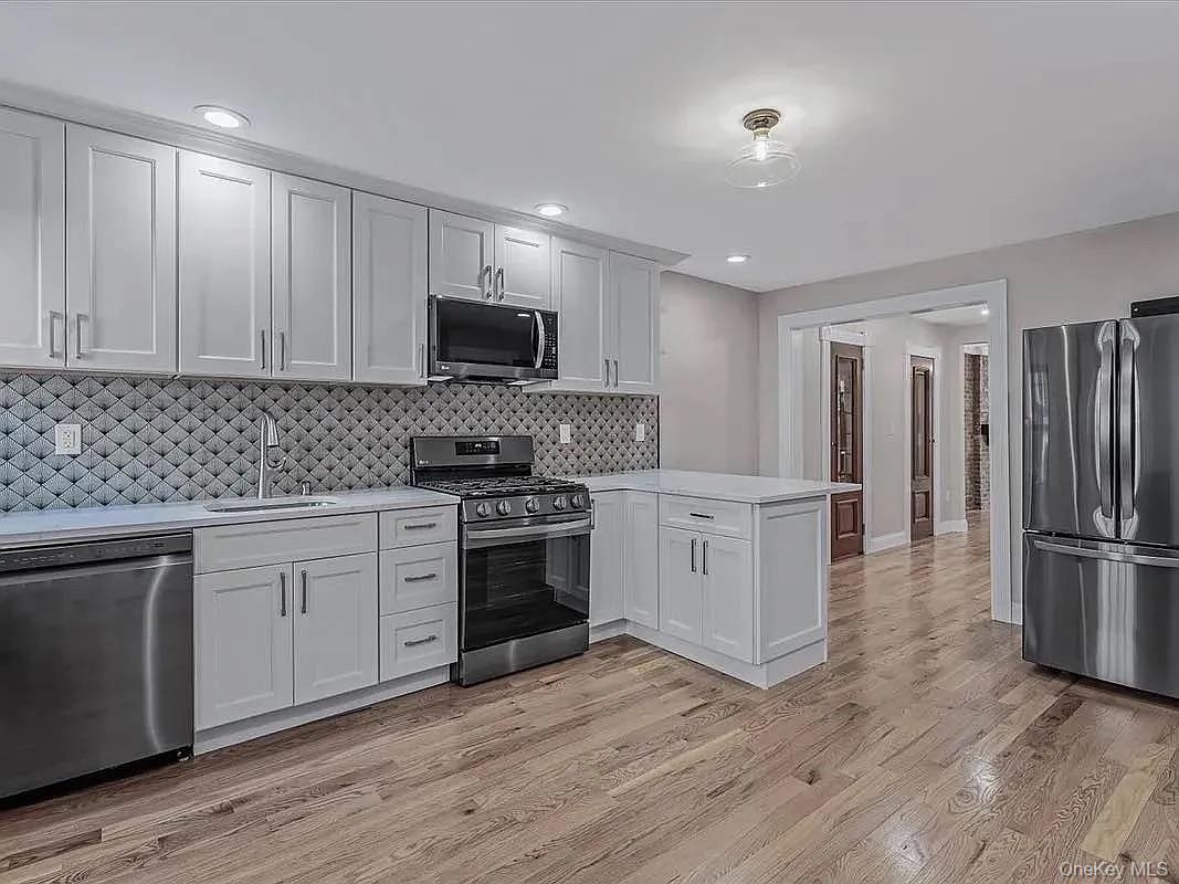 643 Decatur Street, Unit 1 Brooklyn, NY 11233 - Photo 6 of 27 a kitchen with granite countertop a refrigerator stove and wooden cabinets
