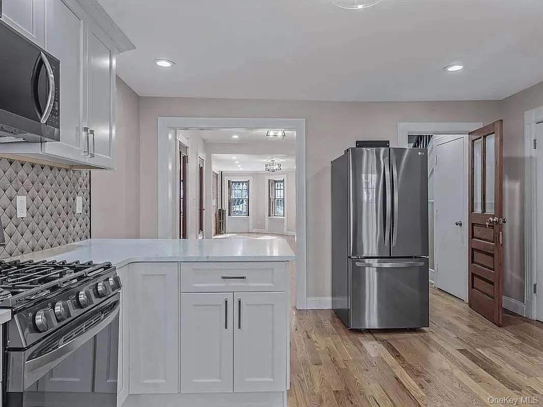 643 Decatur Street, Unit 1 Brooklyn, NY 11233 - Photo 7 of 27 a kitchen with white cabinets and stainless steel appliances
