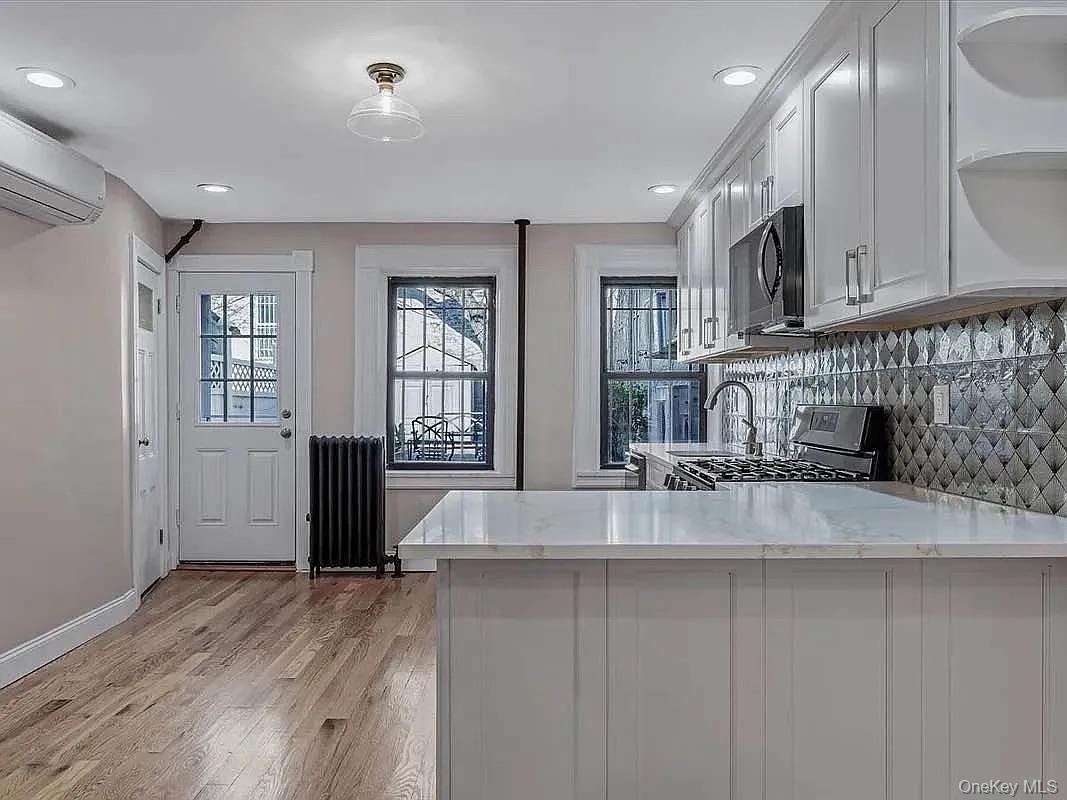 643 Decatur Street, Unit 1 Brooklyn, NY 11233 - Photo 8 of 27 a large kitchen with stainless steel appliances granite countertop a lot of counter space and wooden floor