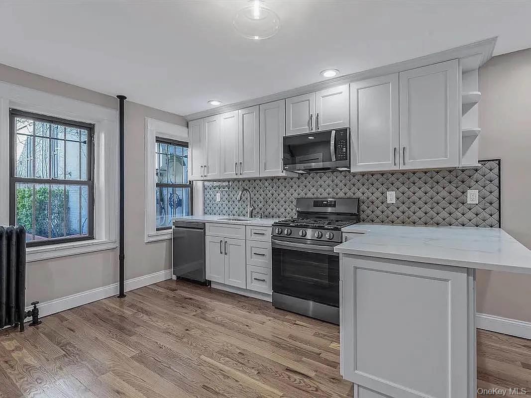 643 Decatur Street, Unit 1 Brooklyn, NY 11233 - Photo 9 of 27 a kitchen with a stove a sink and a microwave