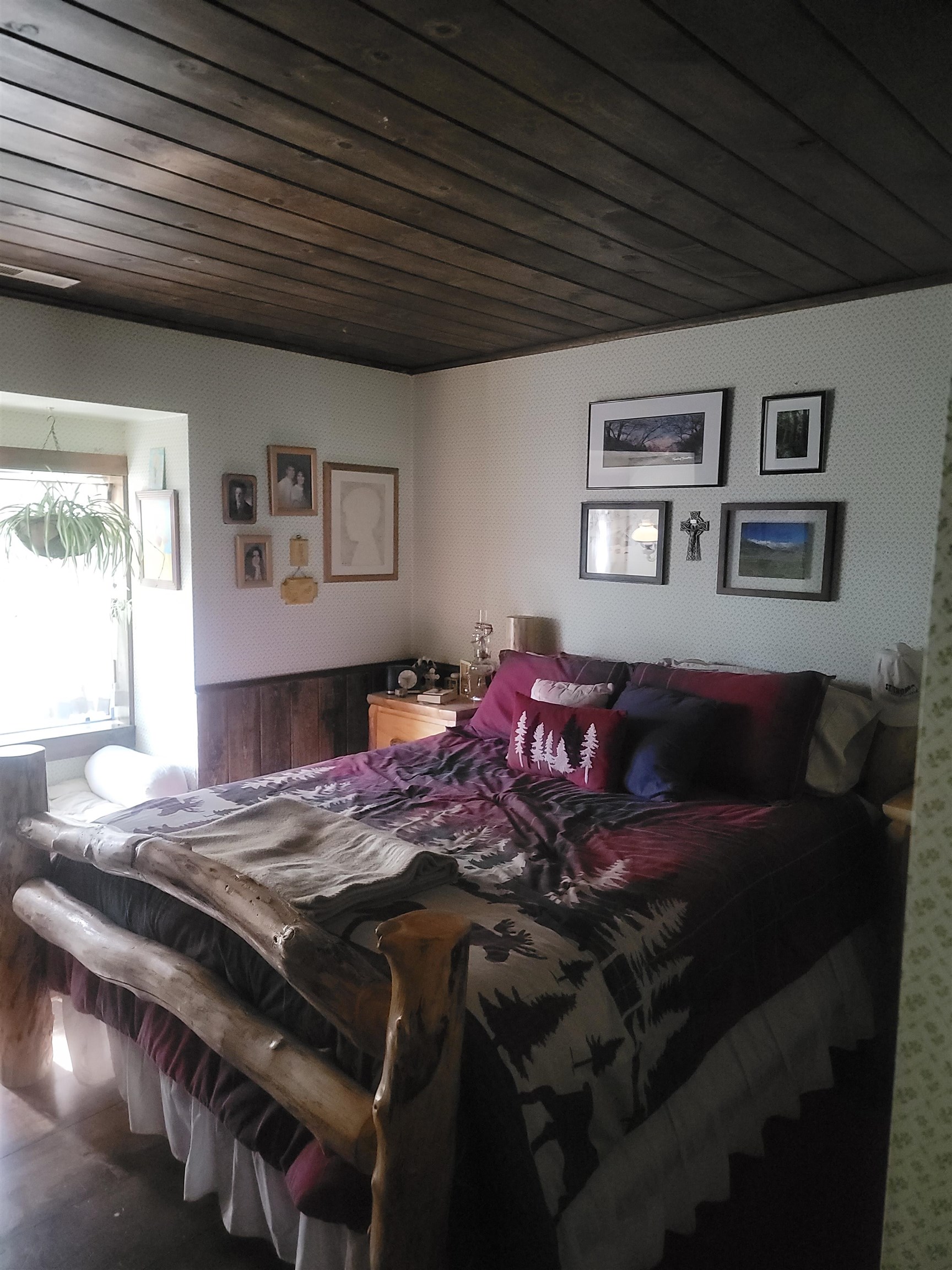 11702 Twin Lakes Road Bridgeport, CA 93517 - Photo 14 of 21 Bedroom featuring a dark wood-planked ceiling, white patterned wallpaper, and partial wood wainscoting