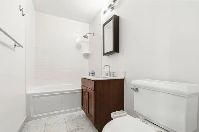 a bathroom with a sink toilet vanity and tub