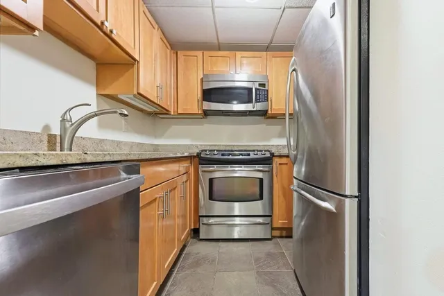 a kitchen with granite countertop a refrigerator stove and microwave