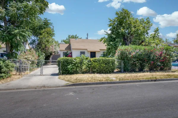 a view of a house with a street and a yard
