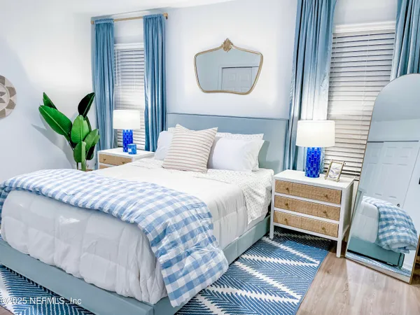 a bedroom with a bed and a potted plant on the dresser