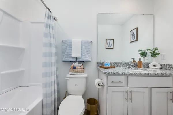 a bathroom with a granite countertop sink a toilet and shower