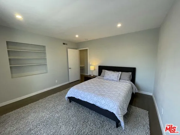 a spacious bedroom with a bed and a cabinets