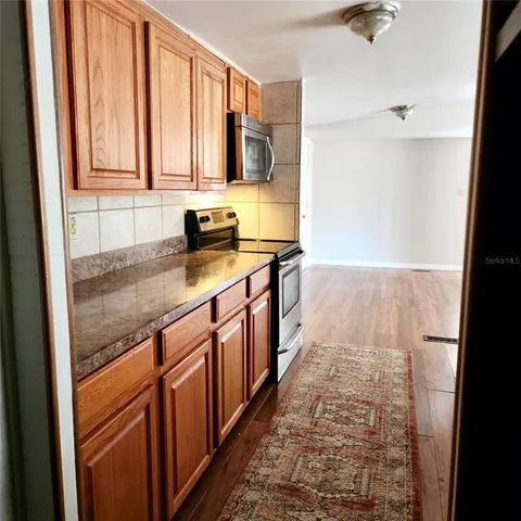 a kitchen with a refrigerator sink and white cabinets