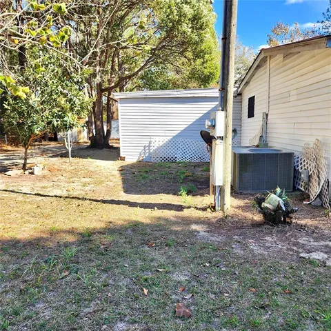 a view of a house with backyard and trees