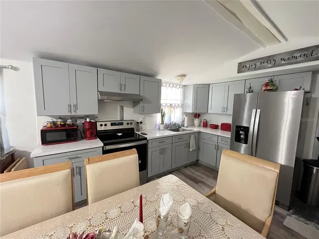 a dining room with kitchen island granite countertop furniture and a large window