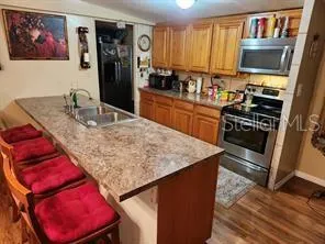 a kitchen with stainless steel appliances granite countertop a stove refrigerator sink and a microwave