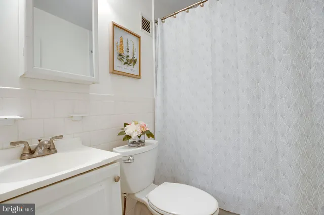 a bathroom with a sink mirror and toilet
