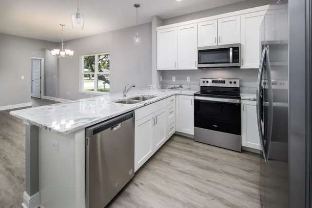 a kitchen with a wooden floors and white cabinets