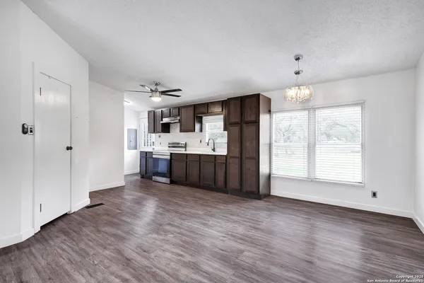 a kitchen with stainless steel appliances a sink wooden floor and a large window