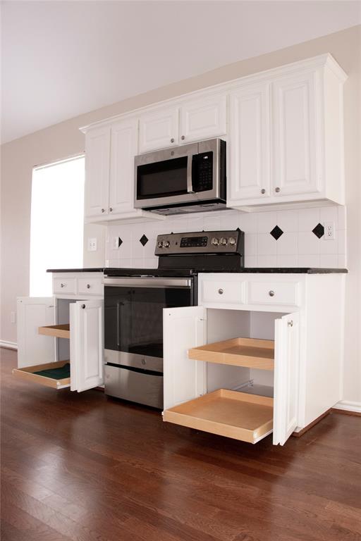 10702 Huntington Road Frisco, TX 75035 - Photo 4 of 23 a kitchen with stainless steel appliances a stove and white cabinets
