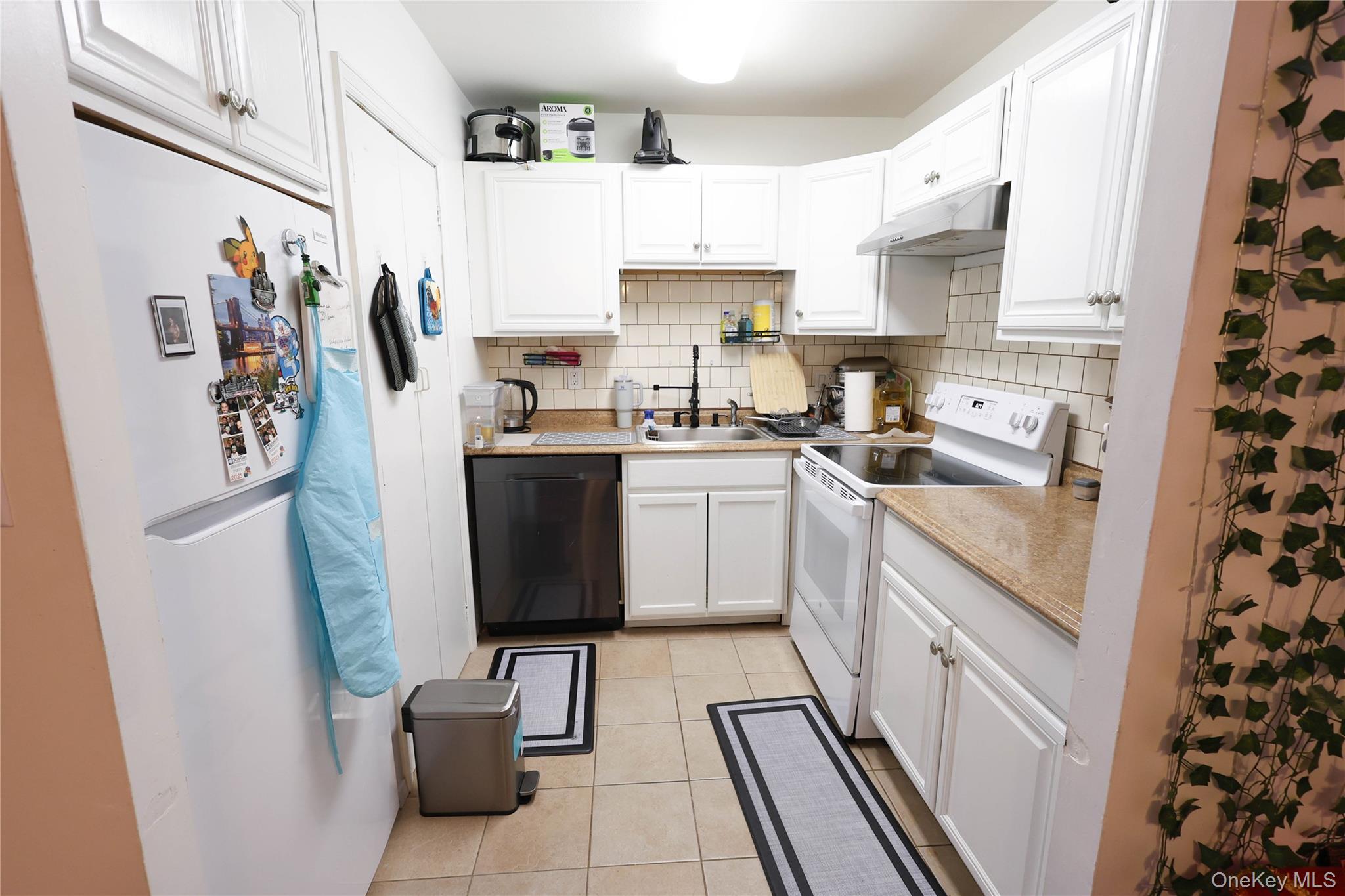 3 Saratoga Court, Unit B Ridge, NY 11961 - Photo 5 of 15 a kitchen with stainless steel appliances a sink a stove a refrigerator and cabinets